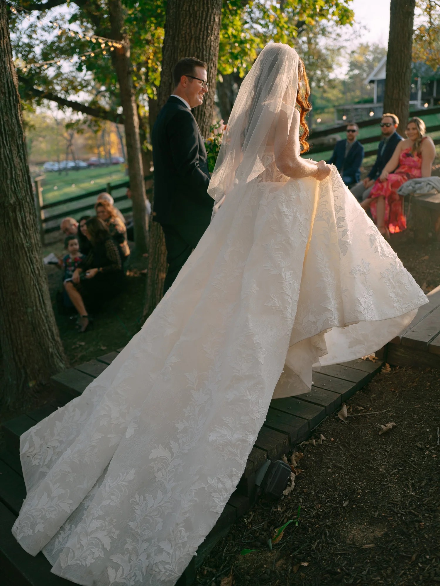Lauren walking toward Adam for their outdoor ceremony at The Barn at Riverbend
