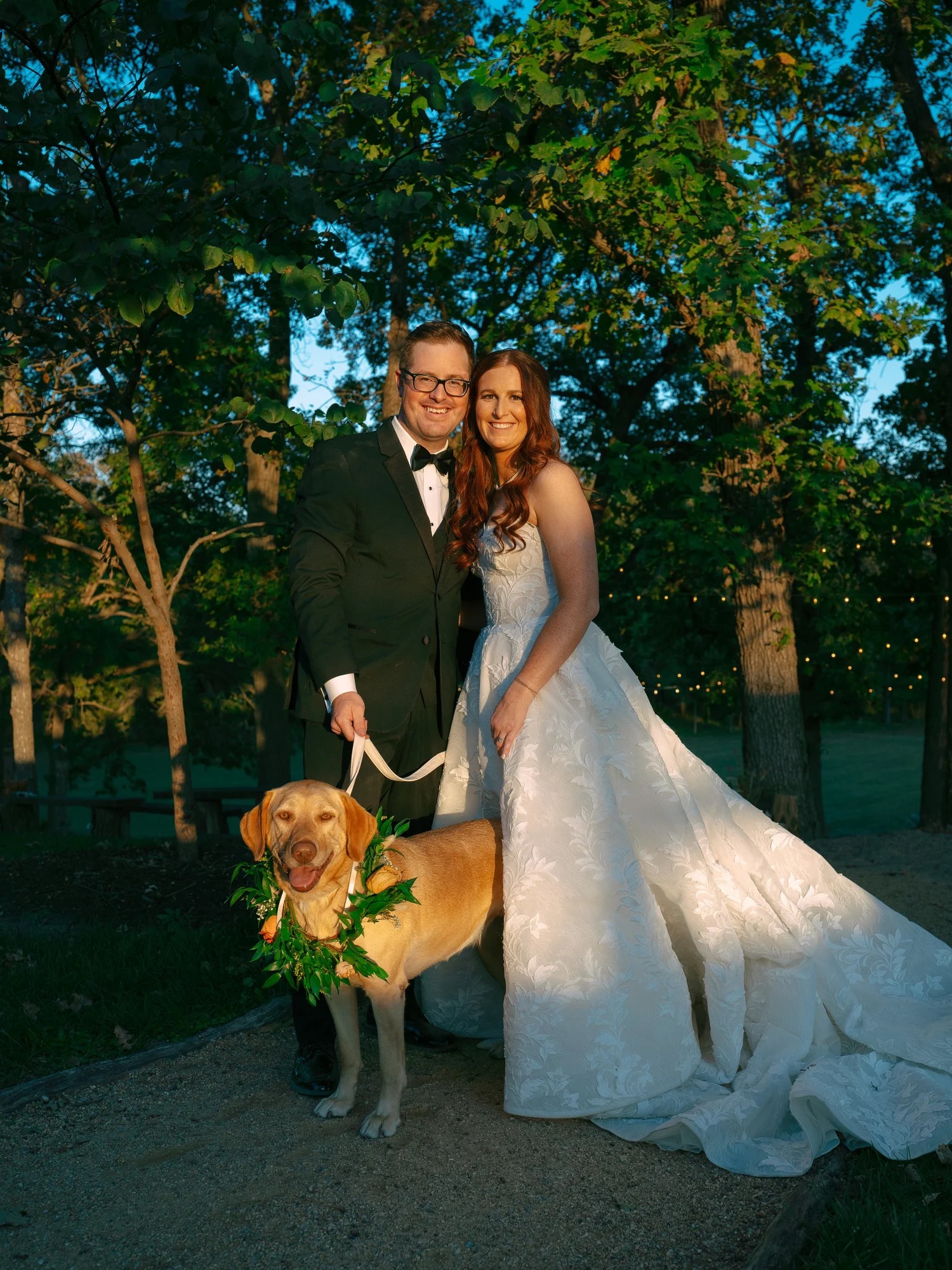 Lauren and Adam with their flower adorned dog at The Barn at Riverbend