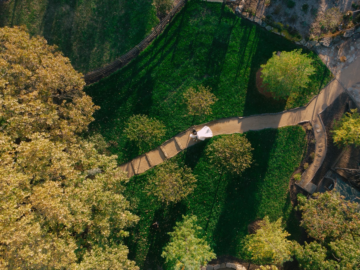 Aerial view of Lauren and Adam walking together on the grounds of The Barn at Riverbend