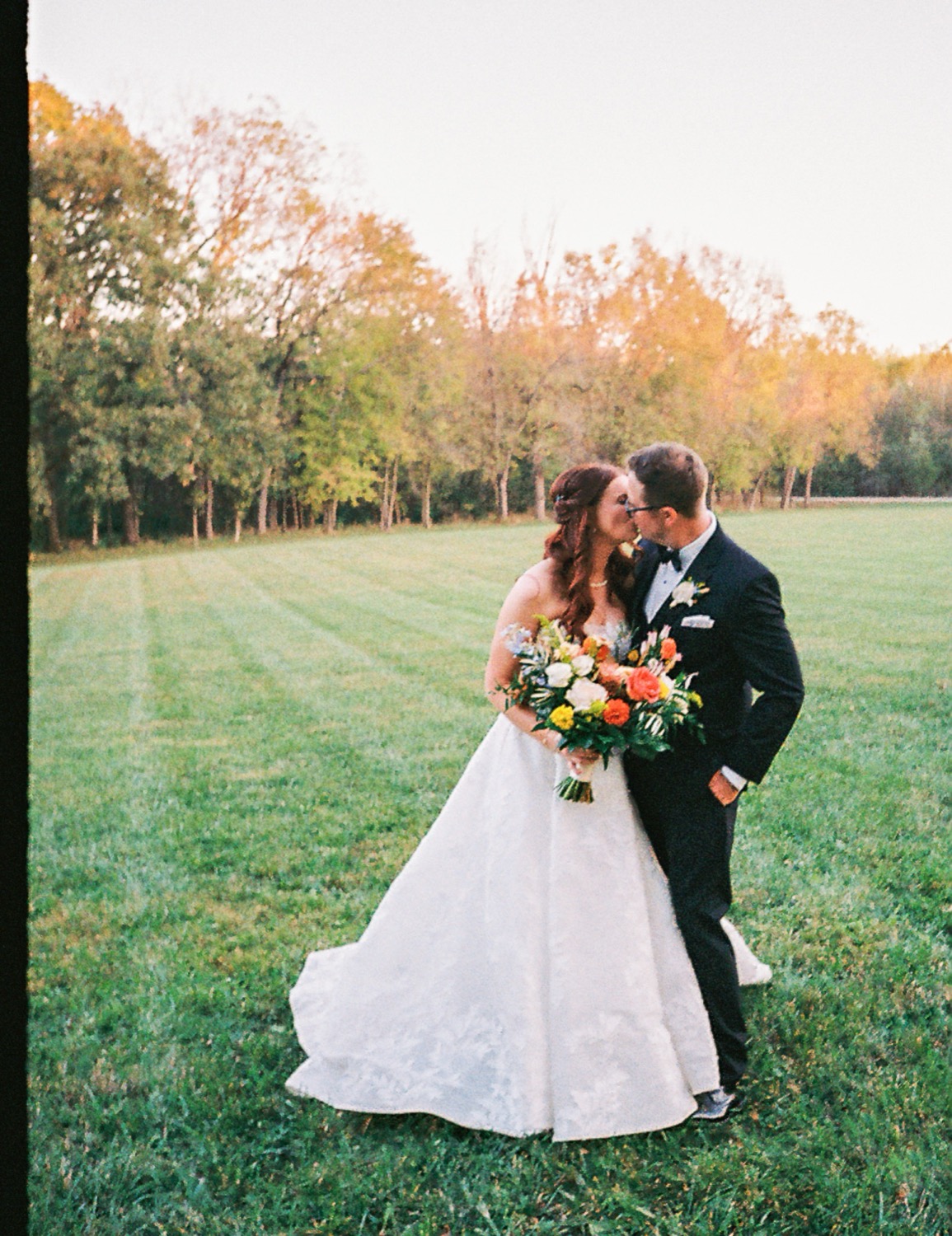 Film photograph of Lauren and Adam kissing on the lawn
