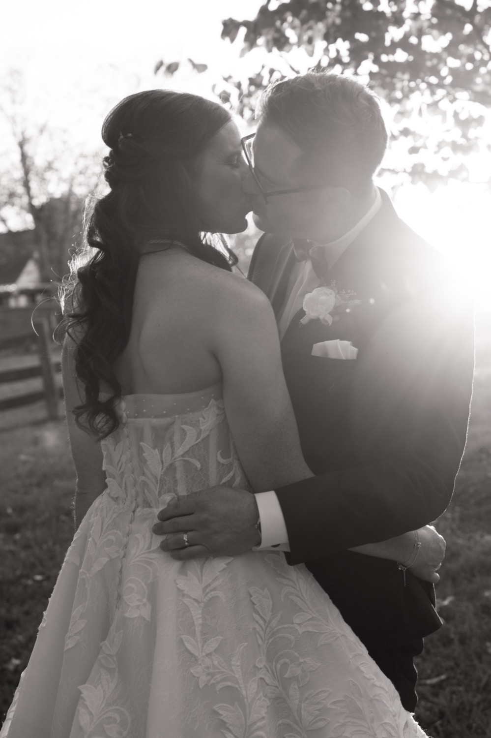 Black and white portrait of Lauren and Adam kissing at sunset