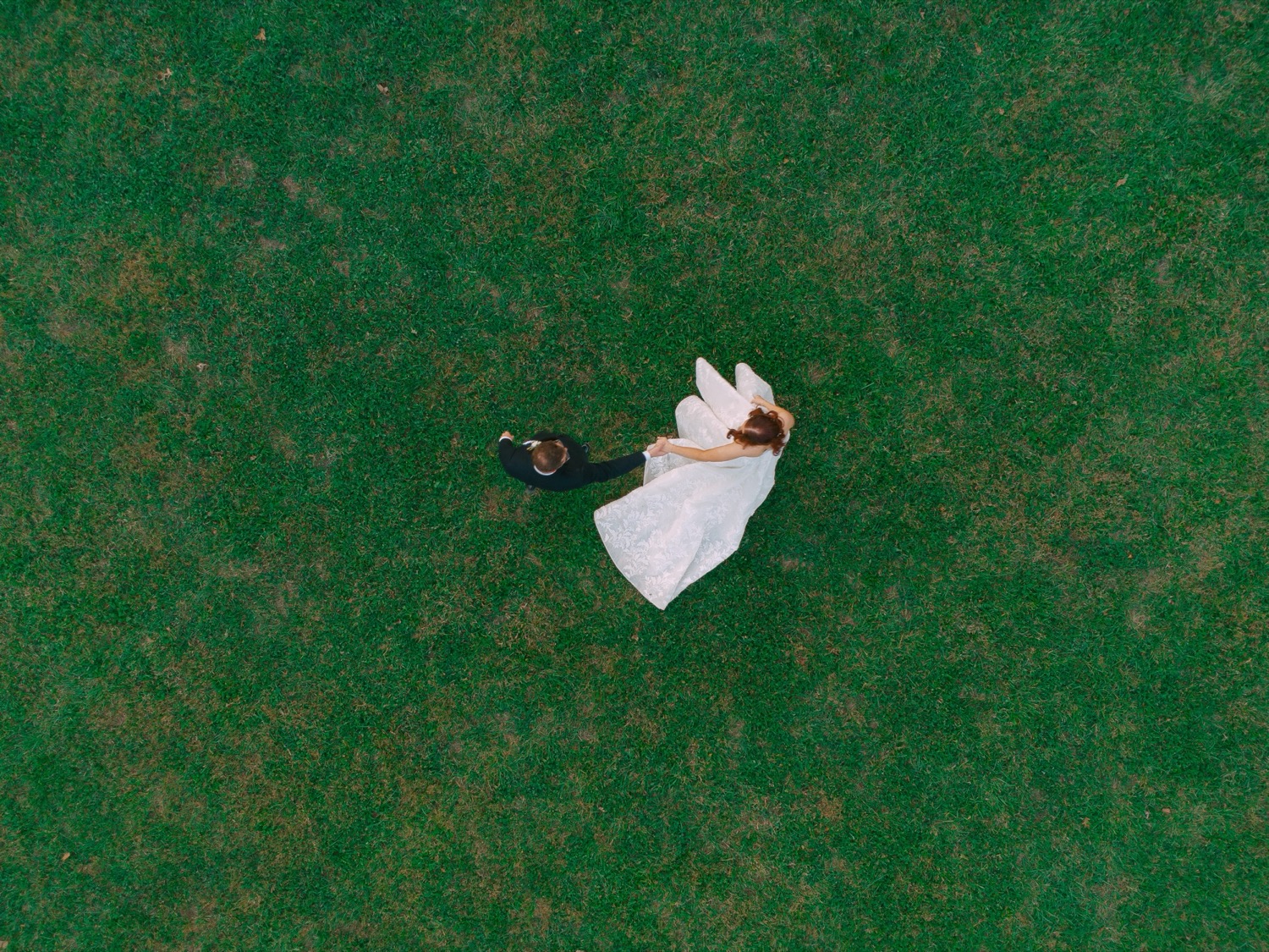 Aerial view of Lauren and Adam dancing on the lawn
