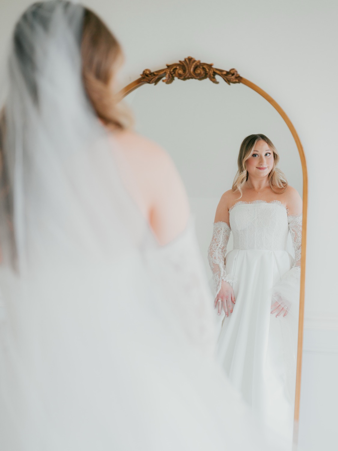 Lauren in her wedding dress reflected in an ornate mirror