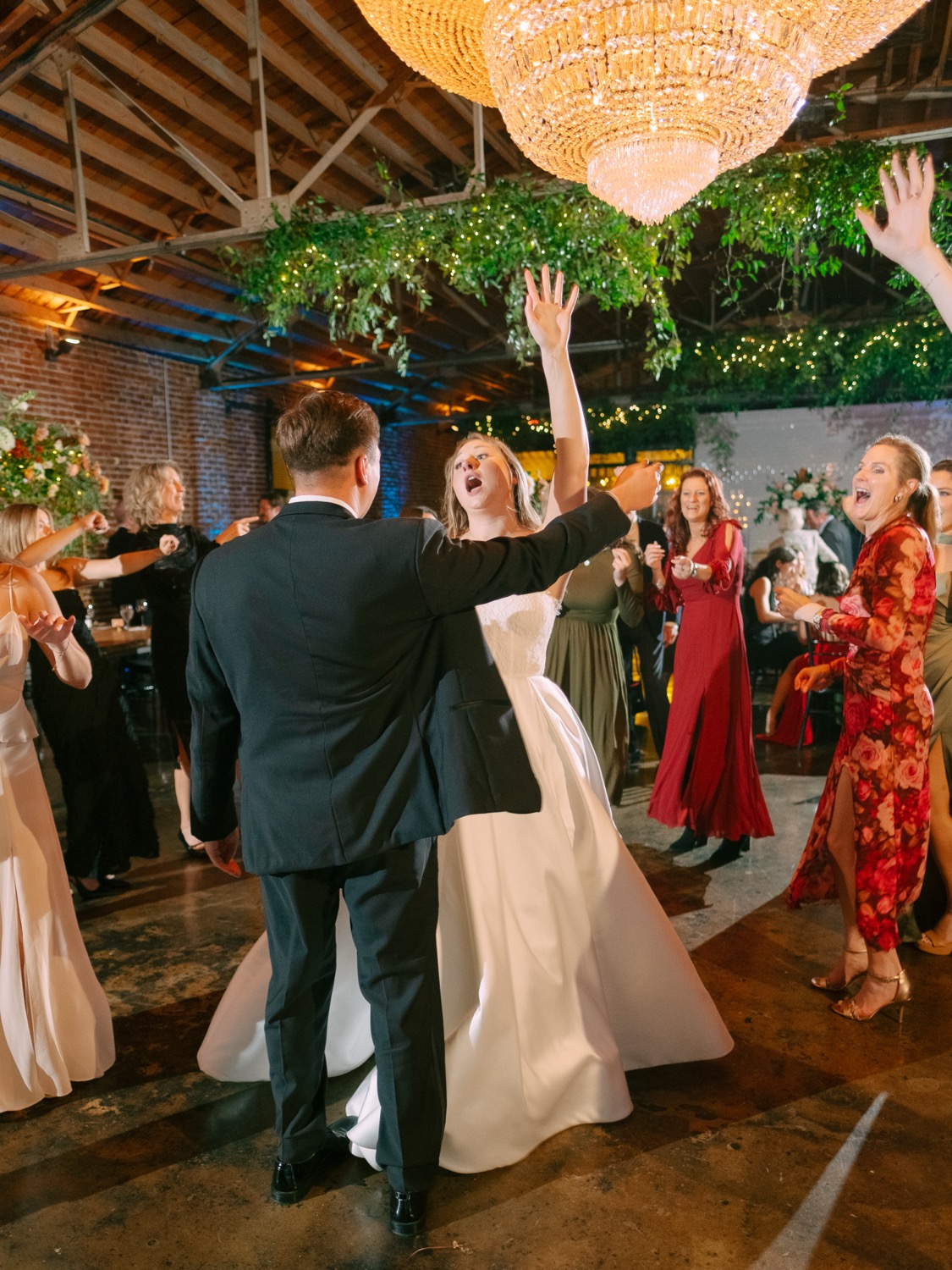 Lauren and Logan dancing under chandeliers at The Guild
